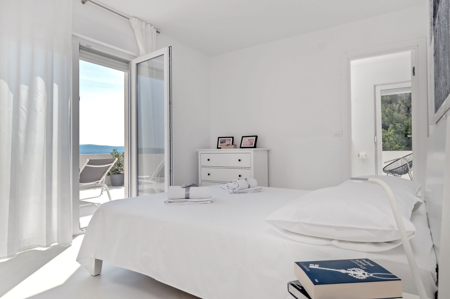 Bedroom on the 2nd floor with a double bed, bathroom, and exit to balcony