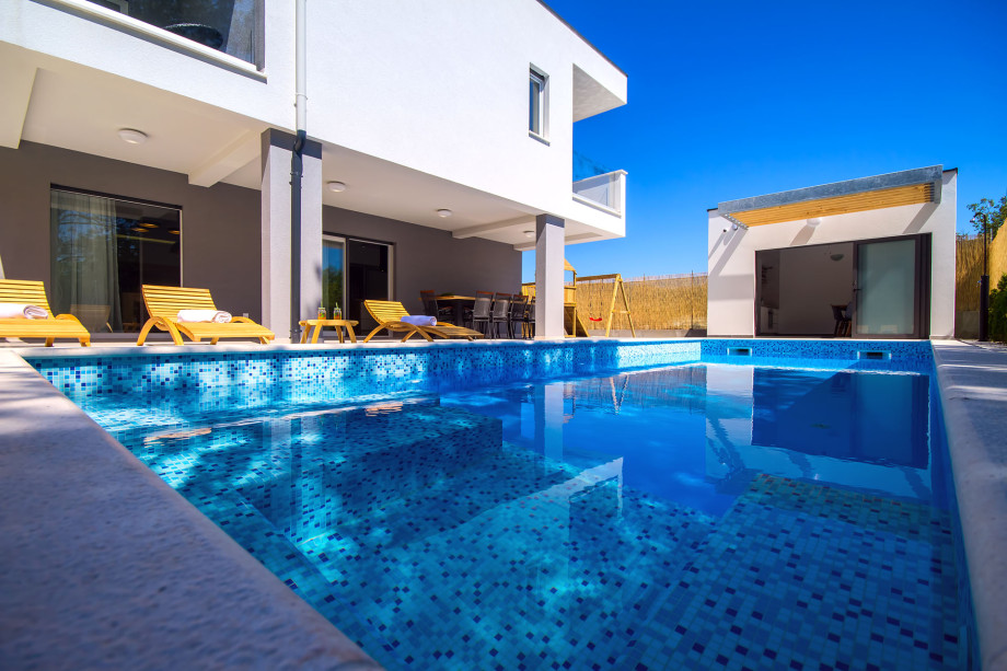 Heated 33sqm pool with attached 5sqm whirlpool and 8 comfortable lounge chairs