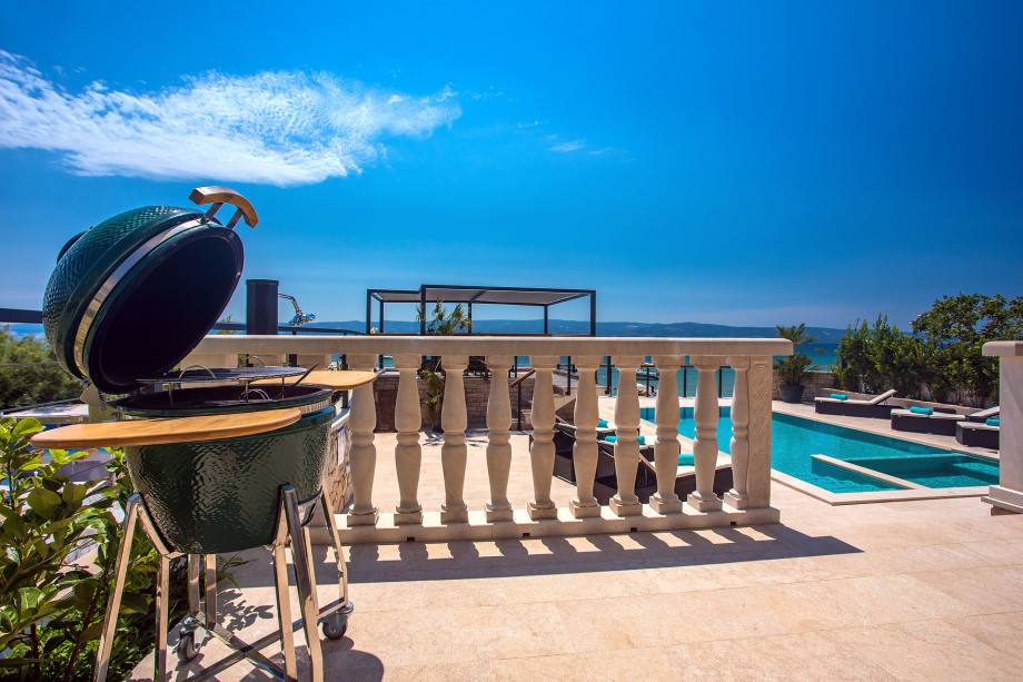 Modern grill located next to the outdoor dining area and with pool and sea view