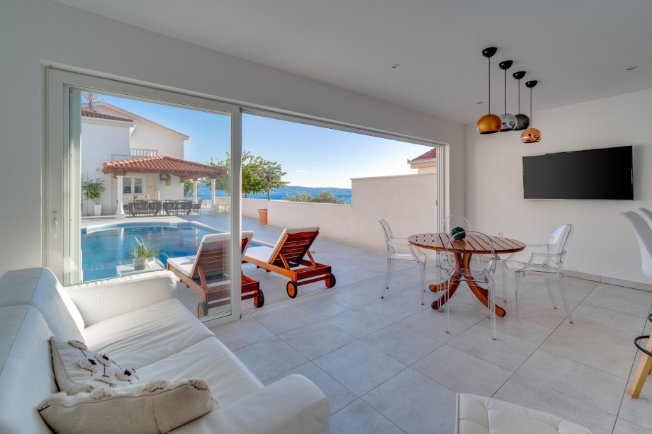Modern summer kitchen and lounge area next to the pool