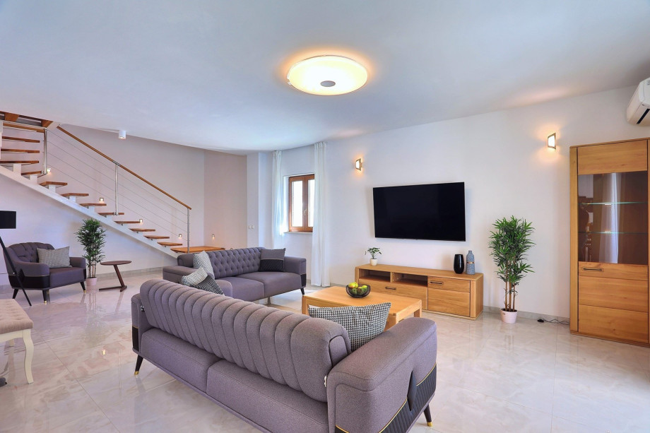 Living area with sofas, a smart TV, Finish sauna with a shower, a separate toilet, with direct exit to the pool area and outdoor dining area
