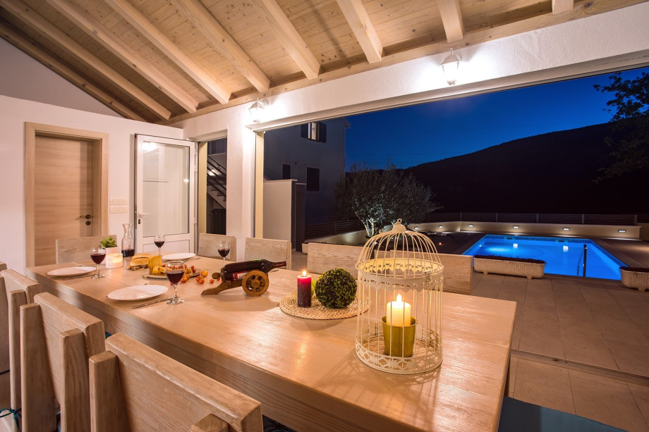 Fully equipped kitchen with dining area and toilet with view on the pool area