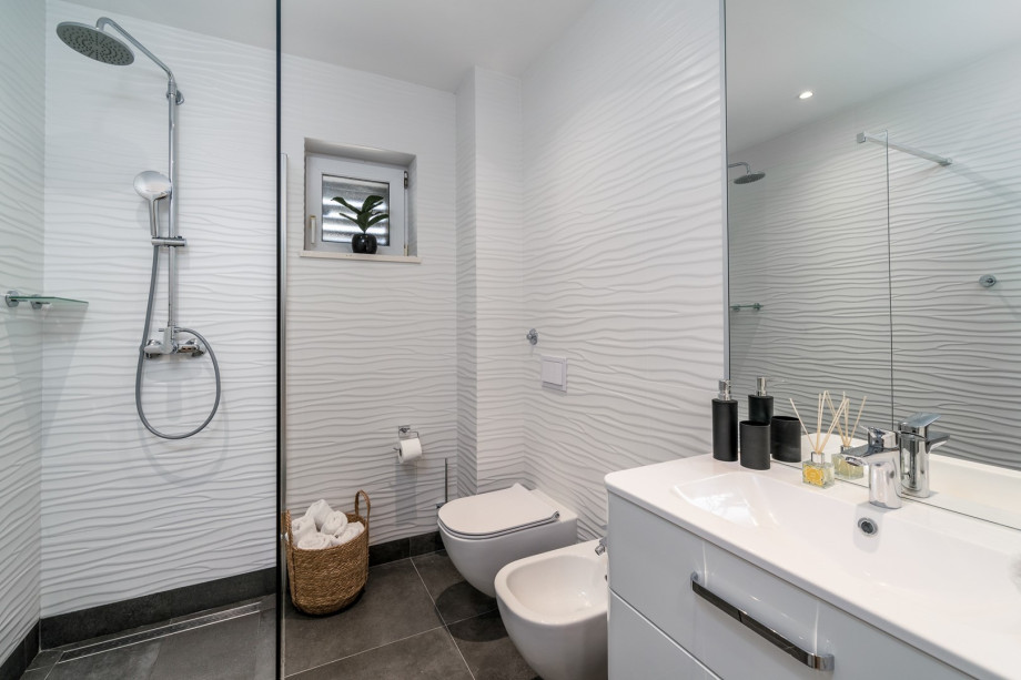 Family bathroom with a shower, toilet and a bidet, and another smaller family bathroom with a shower and a toilet