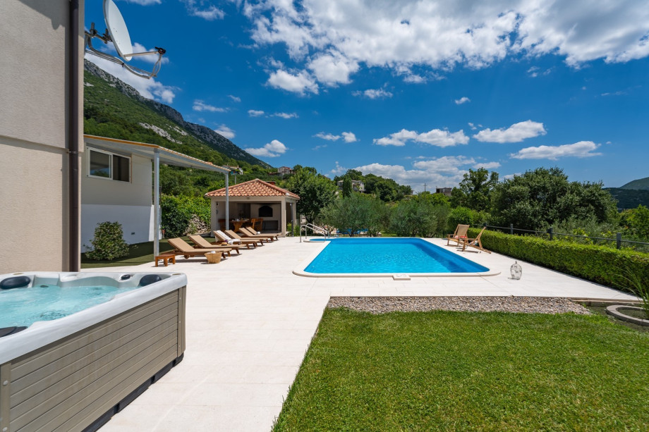 Spacious sun deck area with 8 sun lounge chairs and a shaded area with artificial grass