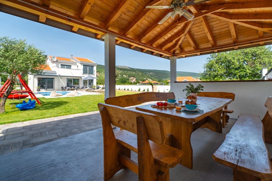 The outdoor area offers a covered outdoor dining area with the traditional barbecue