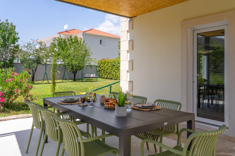 Covered outdoor dining area with a barbecue next to the kitchen