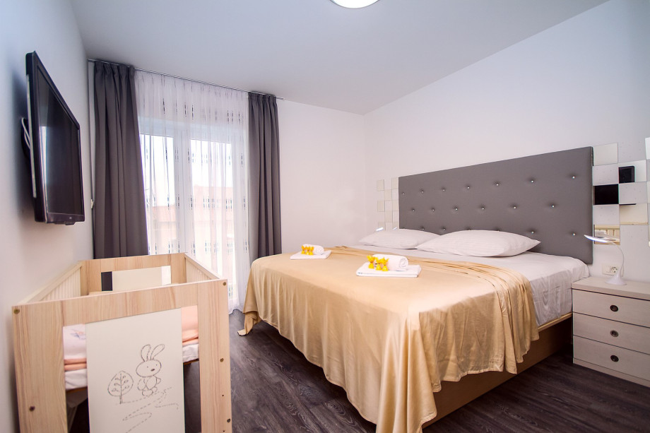 Bedroom No.2 with 200x200 bed, baby cot, lcd tv, air conditioning and balcony