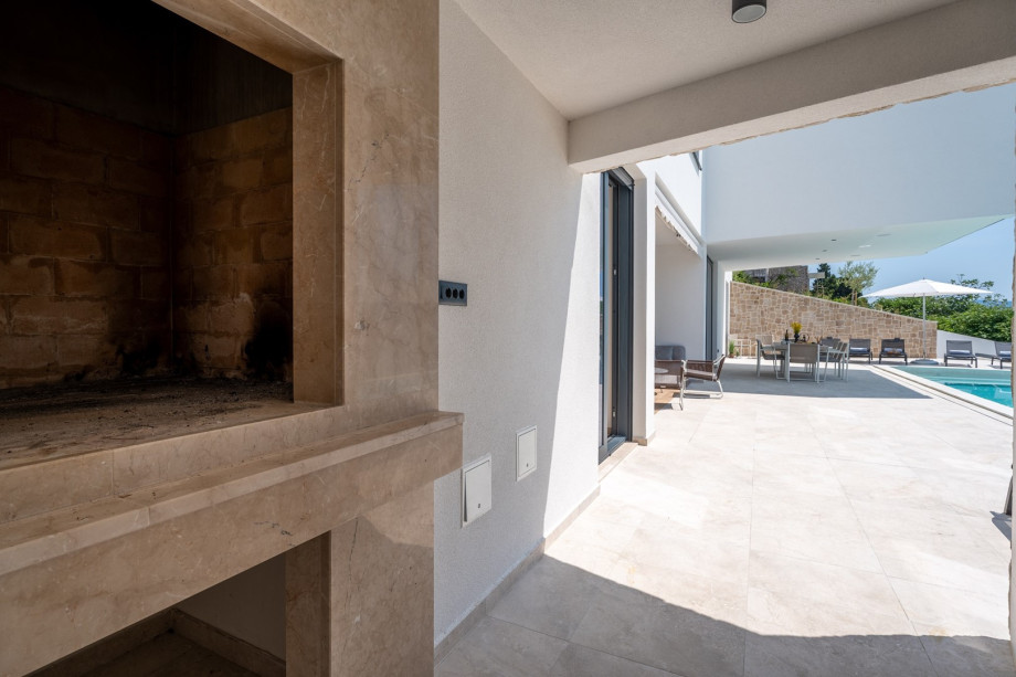 Covered outdoor dining area with a traditional barbecue for maximum relaxation and enjoying the Mediterranean climate