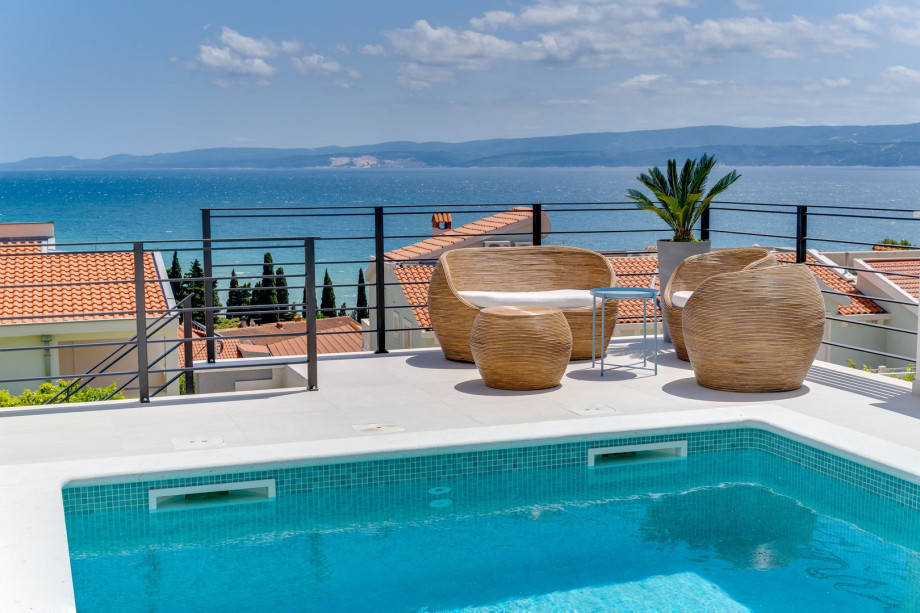 A sun deck area with 6 deck chairs, a comfy lounge corner