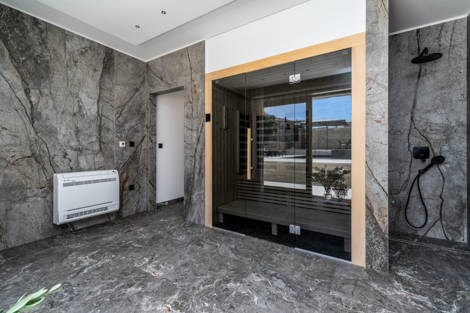 Finnish Sauna room with a shower and glass doors toward the pool area, a very pleasant 15 sqm room for your absolute relaxation