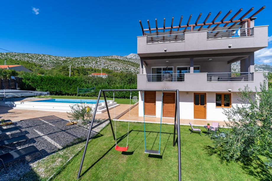 The outdoor area offers a badminton net and swings for youngsters