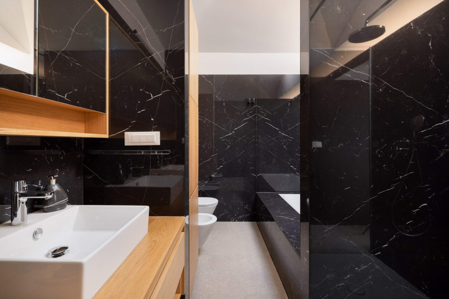 An en-suite bathroom with a bathtub and a shower, a double sink, a toilet, and a bidet.