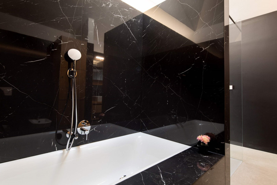 An en-suite bathroom with a bathtub and a shower, a double sink, a toilet, and a bidet.