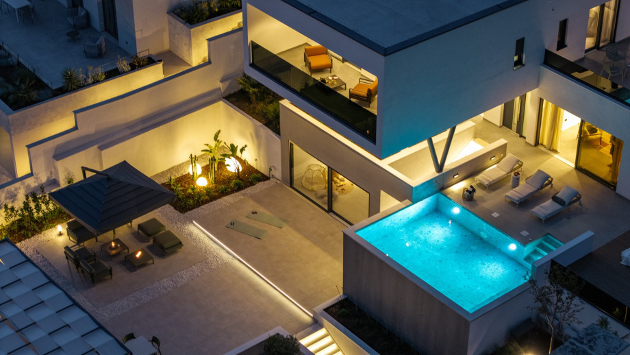 The villa offers seamless indoor-outdoor living with a sauna, lounge chairs, and inviting spaces perfect for relaxing and memorable gatherings