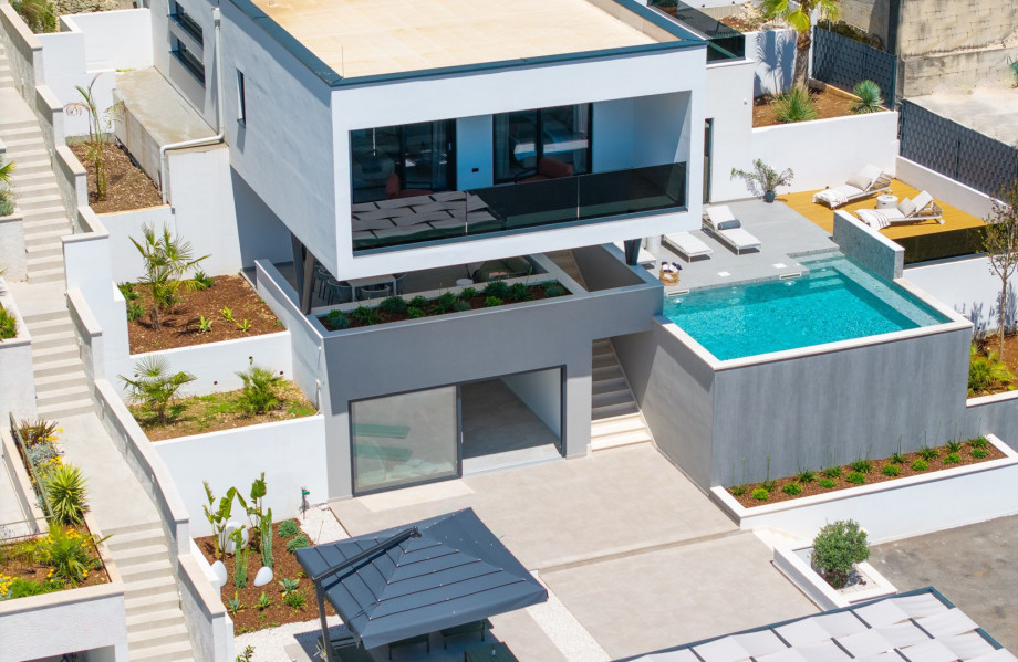 A beautiful villa featuring a heated pool, sauna, comfortable lounge chairs, and modern amenities like complimentary WiFi and flat-screen TV, perfect for a relaxing and memorable stay