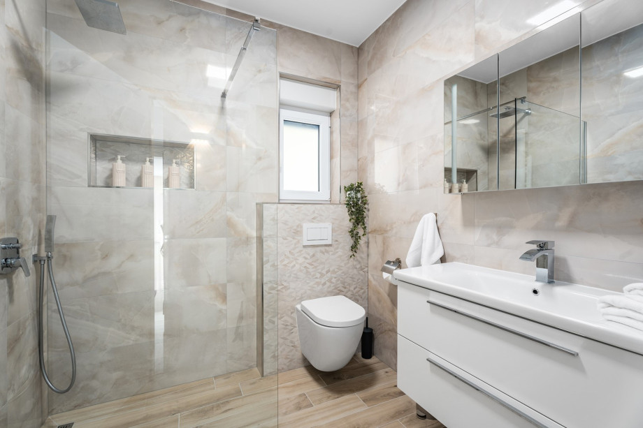 A stylish family bathroom with a shower, toilet, and sink