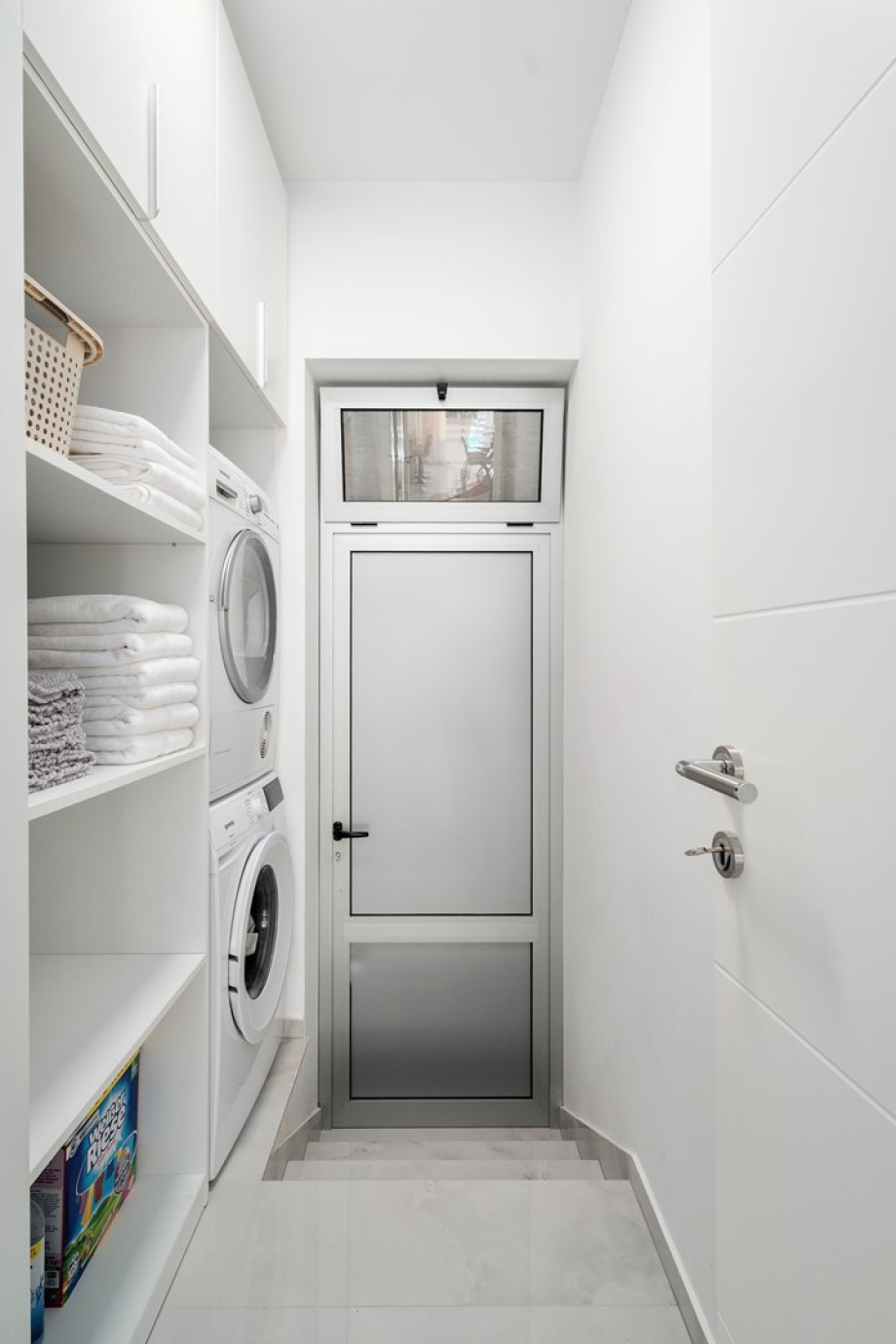 A laundry room with a washing machine, dryer, and ironing amenities.