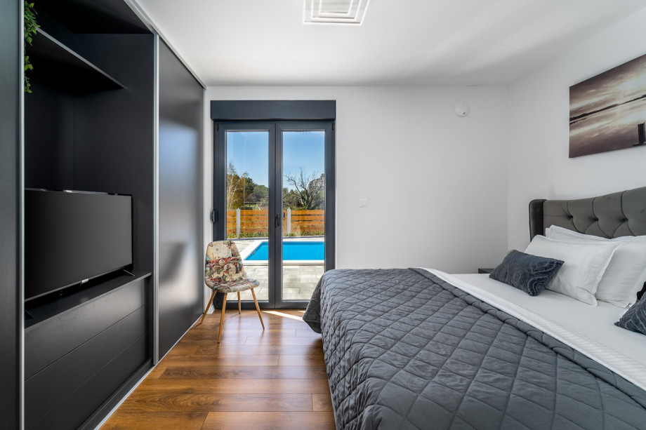 Bedroom No1 with king size bed 180cm x 200cm, en-suite bathroom with shower, a TV, Air-condition and exit toward pool area