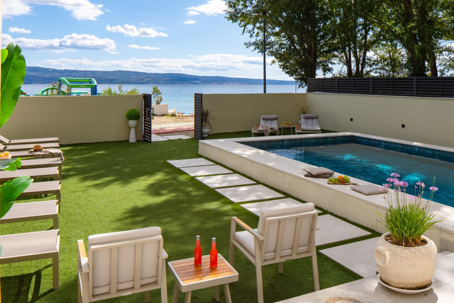 The sun deck area with 14 deck chairs, an outdoor shower, summer kitchen