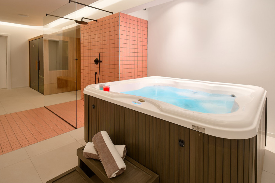 A spa room with a Finnish Sauna, an indoor Whirlpool (a Hot-Tub), a shower and a toilet