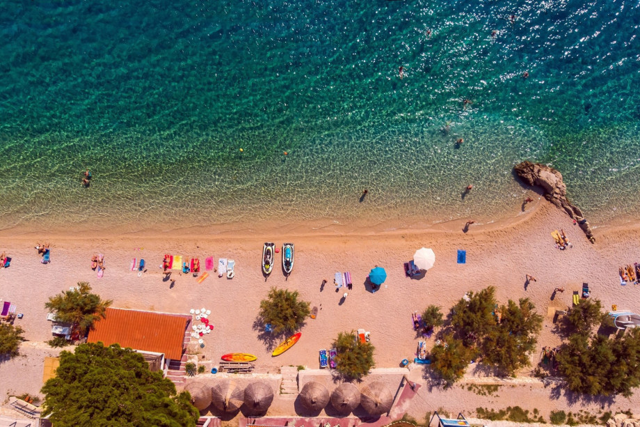 Sandy beach in Duće with crystal clear sea and natural shadow