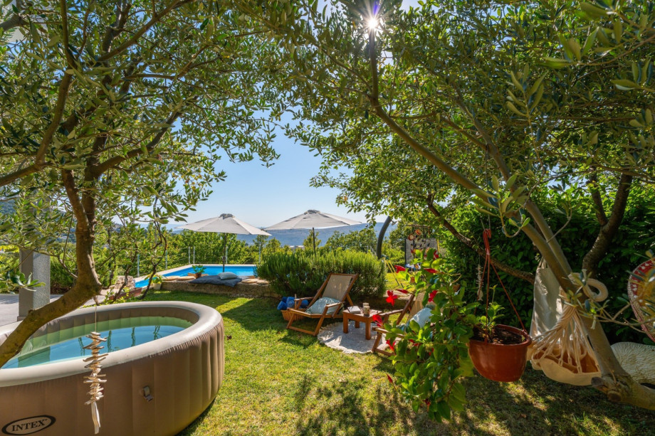 Grassplot with Softub Whirlpool, a lounge corner under the olive trees as a perfect spot to read and relax