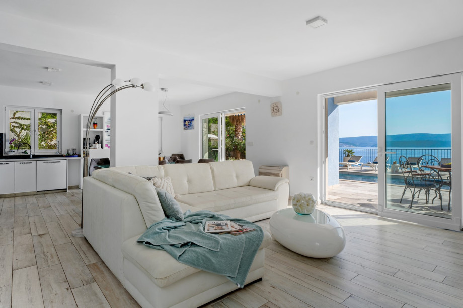 Modern furnished living area with exit to the pool.