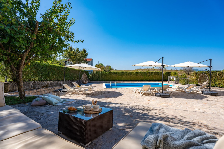 Tranquil outdoor area by a pool with a comfortable seating area