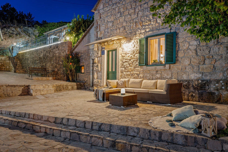 A charming stone terrace at dusk, with a warm outdoor lighting