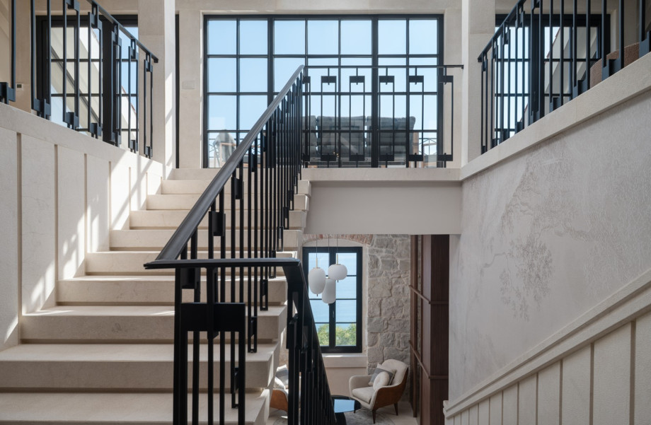 The internal staircase leads to airy living areas featuring large windows and natural light.