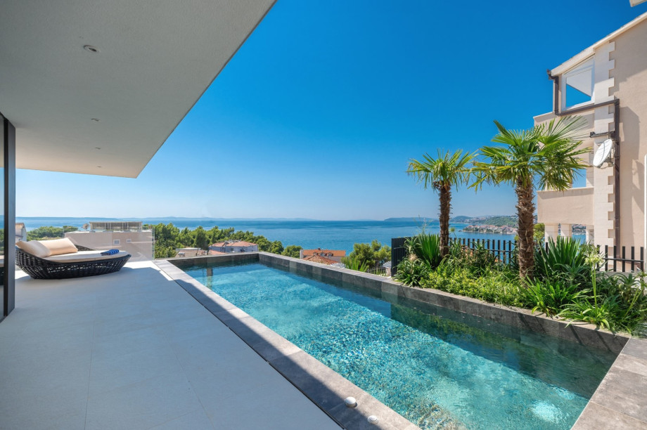 The outdoor area offers a sun deck with a sea view, a private and heated pool of 25.2 m2 (9m x 2.8m) with hydromassage, and a fully automated salt electrolysis system
