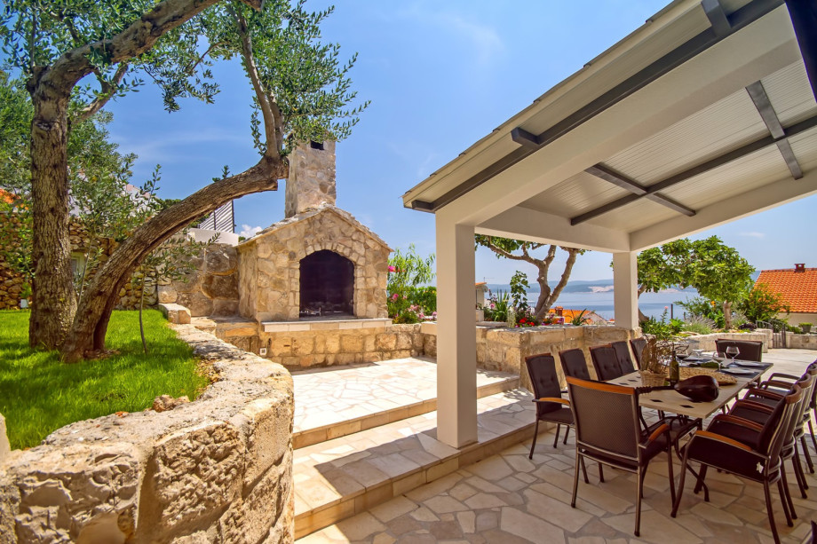 Outdoor dining area next to the grill and pool, direct exit from the kitchen