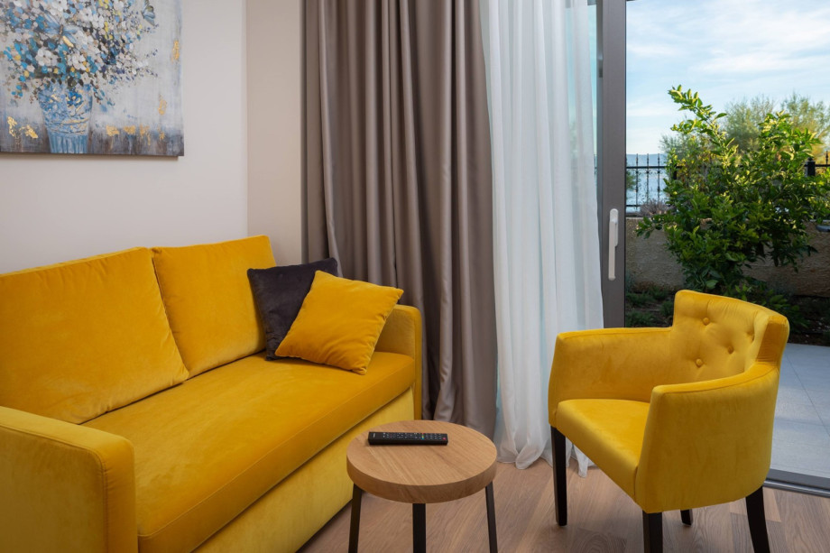 Sofa and lounge area in Bedroom No4 with beach and outdoor dining views, ground