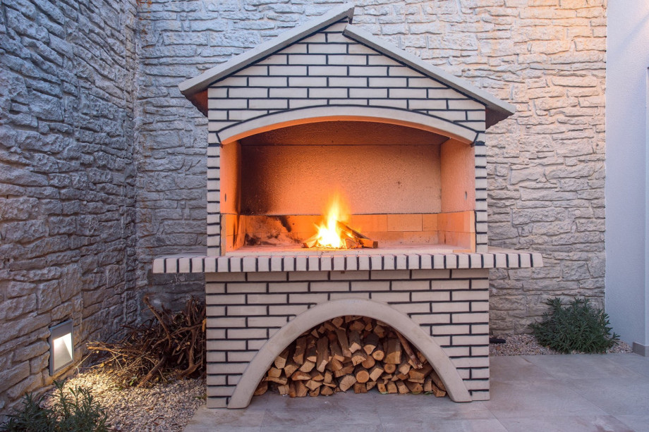 Barbecue next to outdoor dining table