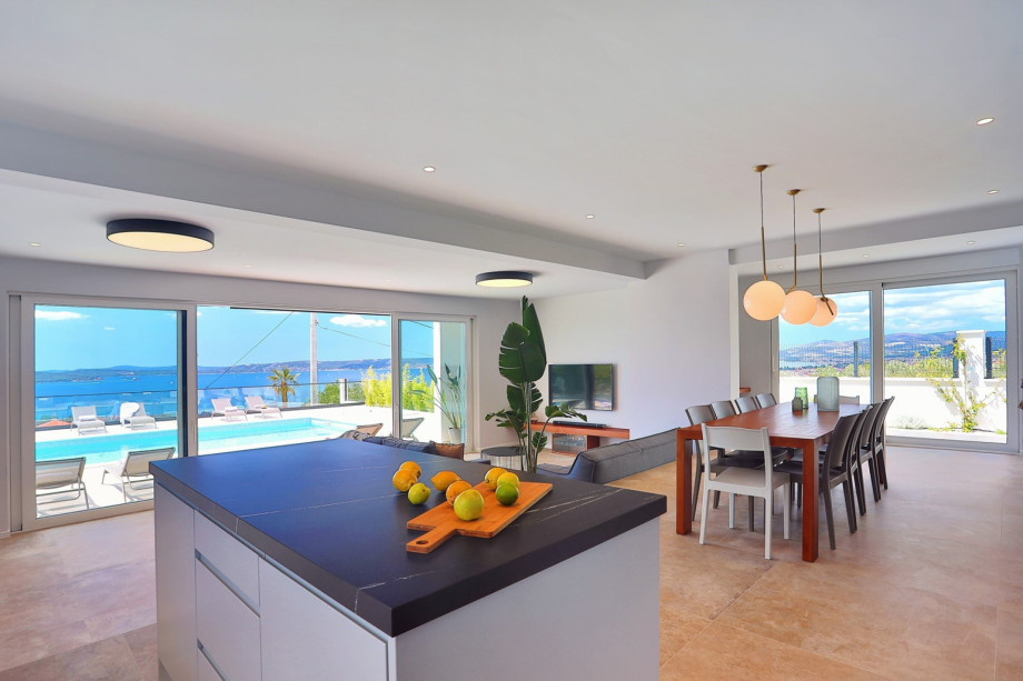 The living area has glass walls toward the pool and outdoor area.