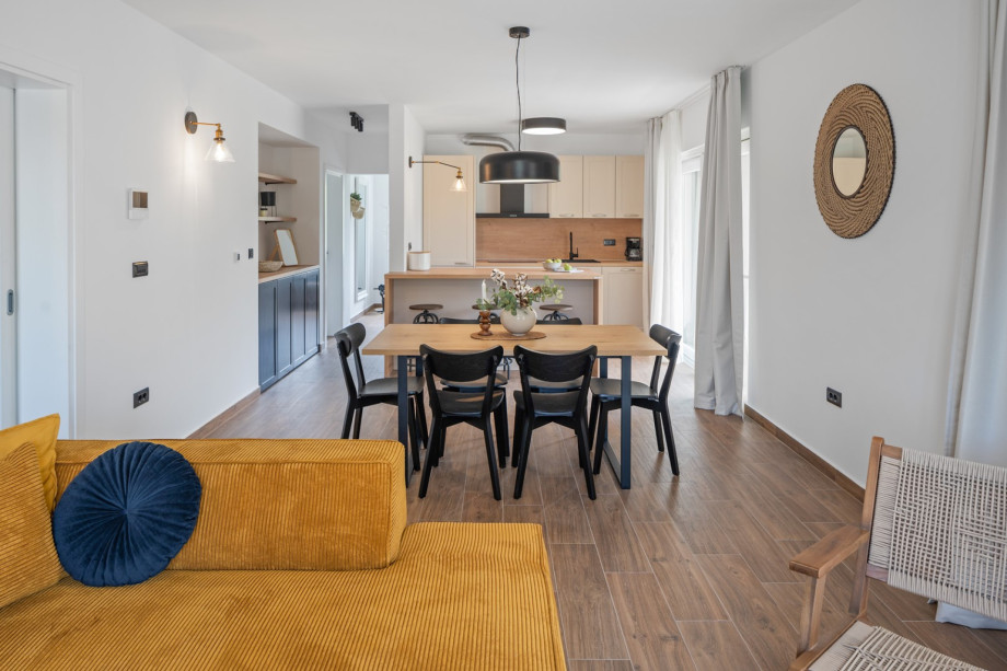 A fully functional kitchen with a kitchen island and balcony, a dining table that seats six