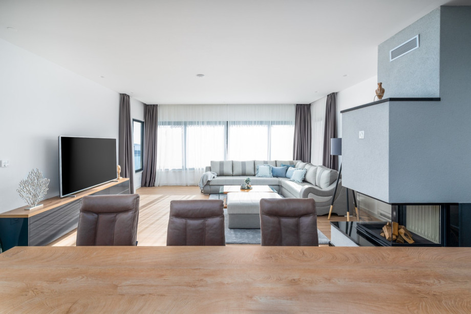 Spacious living room with a flat-screen TV, A/C, a fireplace, a sofa, amazing sea views, and a pool view.