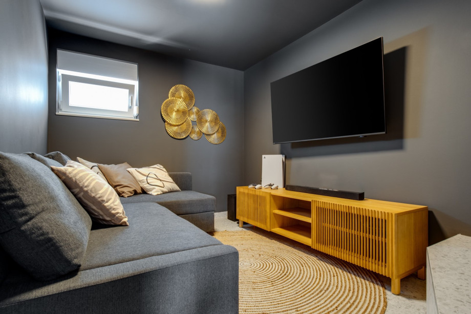 Media room (7,6sqm) with a sofa, a TV, PlayStation 5, A/C, and free Starlink internet (WiFi)
