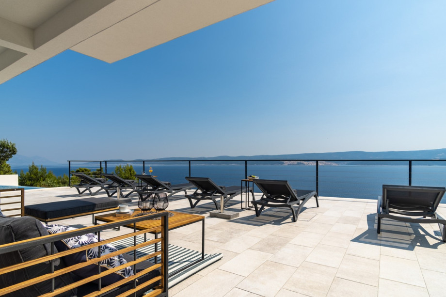 Spacious sun deck area with 8 deck chairs, 2 sun umbrellas, a lounge corner, an outdoor shower and a Table tennis